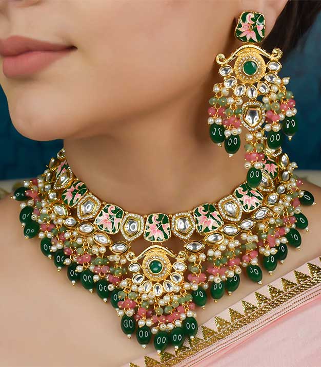 Chicasuu presents this elegant 22k gold plated Kundan jewel from its Nayab collection. It is adored by high quality embellishments and natural stones.

Necklace Length : 8 inches
Earring Length : 3.5 inches
Maantikka : 6 inches
Collection Name : Nayab
Total Weight : 215 gm
Contains : 1 necklace, 1 pair of earrings, 1 Maantikka