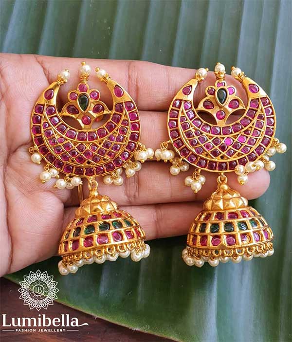 Half Moon Kempu Jhumkis has moon and Miscellaneous designs on it. Moon design is bedecked with glittering ruby stones. Miscellaneous design on it is festooned with green and ruby stones. The moon base is decorated with pearl clusters. Jhumka connected to it has two layers of ruby stones separated by a layer of green stones. The base of the earring is decorated with pearl hangings. It surely adds elegance to your ethnic wear.